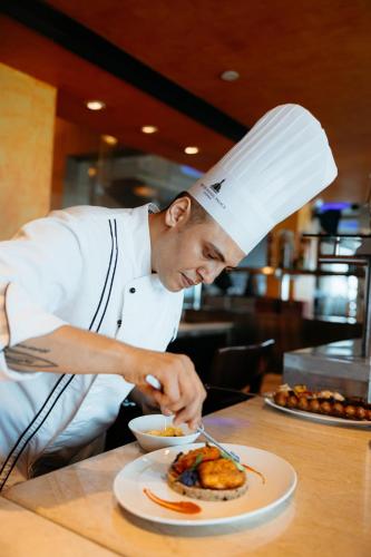 a chef preparing a plate of food on a table at The Taj Mahal Tower, Mumbai in Mumbai