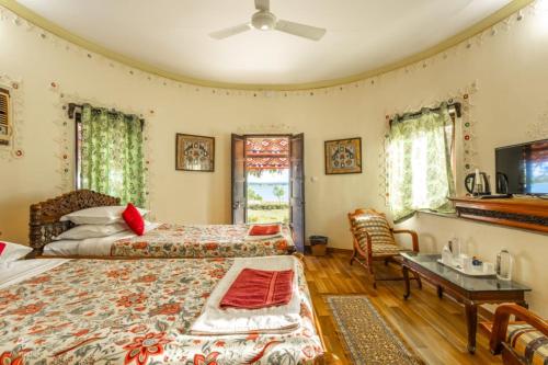 a bedroom with two beds and a flat screen tv at Kutch Safari Resort in Kunria