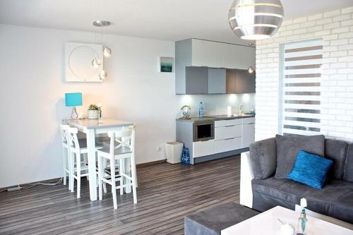 メヘリンキにあるApartament Mechelinkiのリビングルーム(ソファ、テーブル付)、キッチンが備わります。