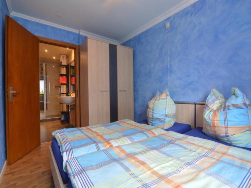 a bedroom with a large bed with blue walls at Cosy Holiday Home with Sauna, Terrace in Butgenbach