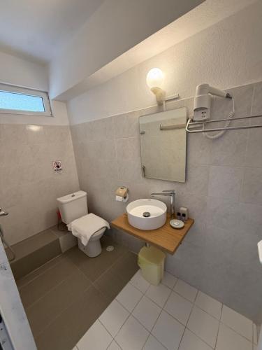 a bathroom with a toilet and a sink and a mirror at Emilios house in Dhërmi