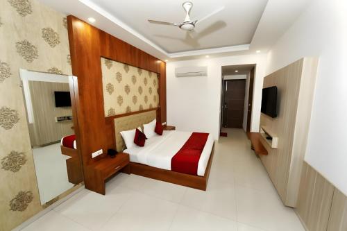 a hotel room with a bed and a television at Almati Hotel - Near Delhi Airport With - free Airport Pickup in New Delhi