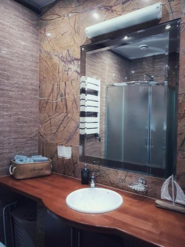 a bathroom with a sink and a large mirror at Apartamenty Biały Kamień in Wałbrzych