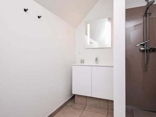 a white bathroom with a sink and a mirror at 8 person holiday home in Blåvand in Blåvand