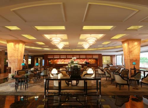 a lobby with chairs and tables in a building at The Taj Mahal Tower, Mumbai in Mumbai