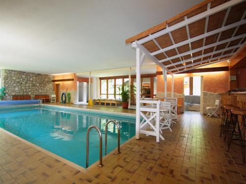 a swimming pool in a house with a table and chairs at Family log cabin in the Alps in Ruhpolding
