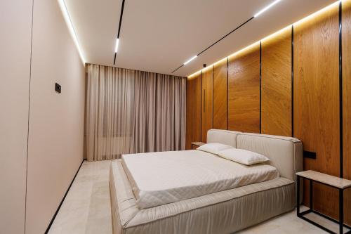 a bedroom with a bed and a wooden wall at Modern luxury apartment 8 in Chişinău