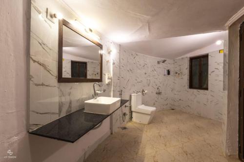 a white bathroom with a sink and a toilet at Kutch Safari Resort in Kunria