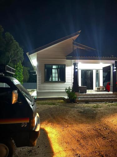 une maison avec une voiture garée devant la nuit dans l'établissement Aqilla Homestay Besut, à Kampung Kuala Besut