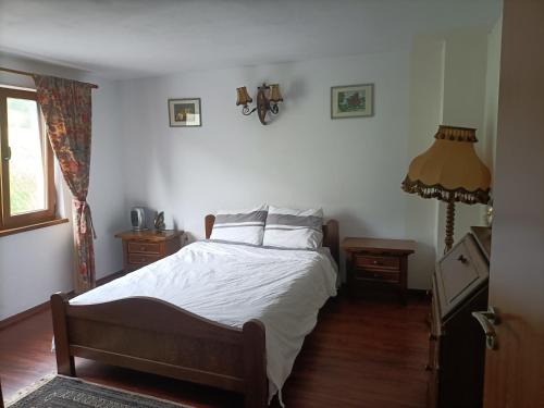 una camera da letto con un letto con lenzuola bianche e una finestra di Cabana Țibleș a Suplai