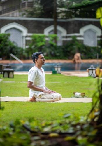 a man sitting on the grass in a park at The Taj Mahal Tower, Mumbai in Mumbai