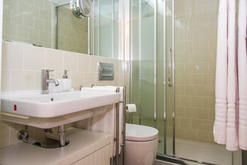 a bathroom with a sink and a toilet and a shower at Liiiving in Porto | Blue Flower Apartment in Porto