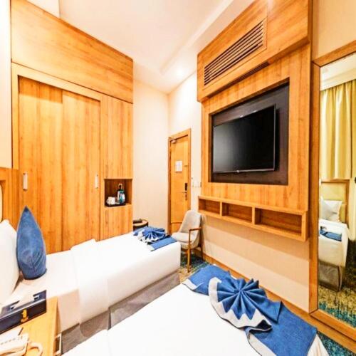 a room with two beds and a flat screen tv at Sunday Luxury Central formerly Anan hotel in Riyadh