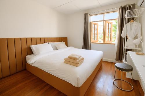 a bedroom with a bed with towels on it at Laid back Pool Villa Chiang Rai in Chiang Rai