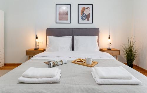 a bedroom with a bed with towels and a tray of food at Central Thessaloniki Boutique in Thessaloniki