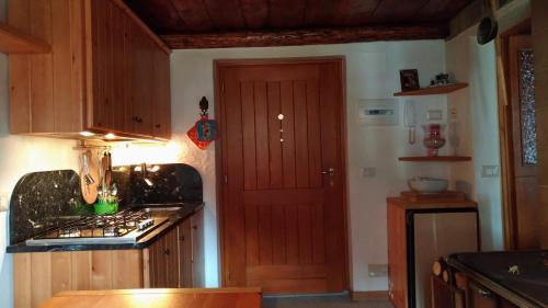 a kitchen with a wooden door and a stove at VERO RUSTICO ALPiNO in Madesimo