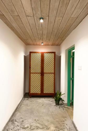 an empty room with a wooden door and a ceiling at Tropicana Hideaway Hikkaduwa in Hikkaduwa