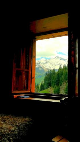 an open window with a view of a mountain at VERO RUSTICO ALPiNO in Madesimo