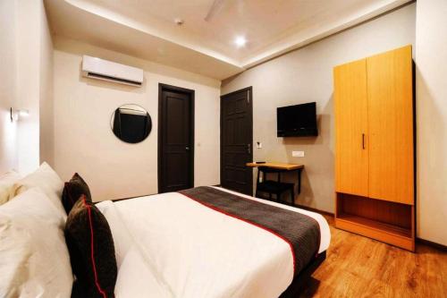 a hotel room with a bed and a television at Perfect Spot By Highly Recommended Hotels in New Delhi