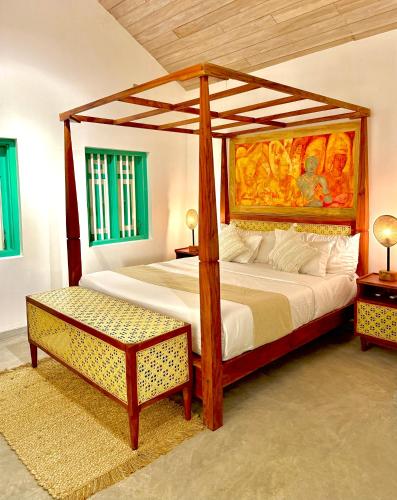 a bedroom with a four poster bed with a canopy at Tropicana Hideaway Hikkaduwa in Hikkaduwa