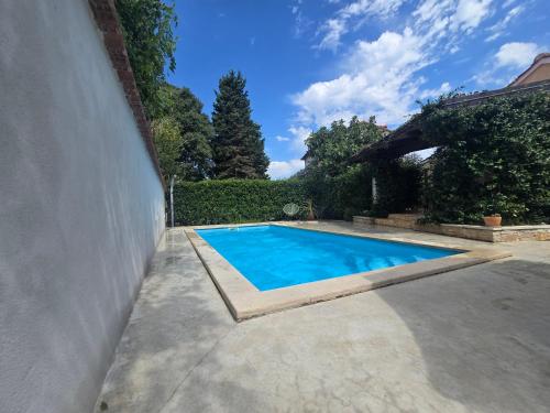 een zwembad in een tuin naast een muur bij Rustic house with private swimming pool in Pula