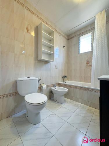 a bathroom with a toilet and a sink and a tub at El Bungalow in Oropesa del Mar