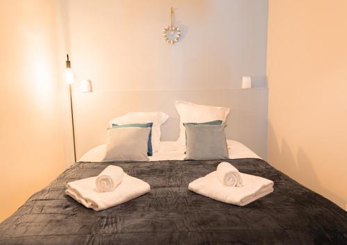 a bedroom with a bed with towels on it at Sur la route des étoilés - BY PRIMO C0NCIERGERIE in Tournus