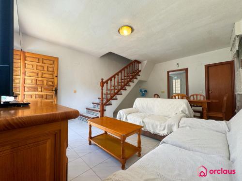 a living room with a couch and a staircase at El Bungalow in Oropesa del Mar