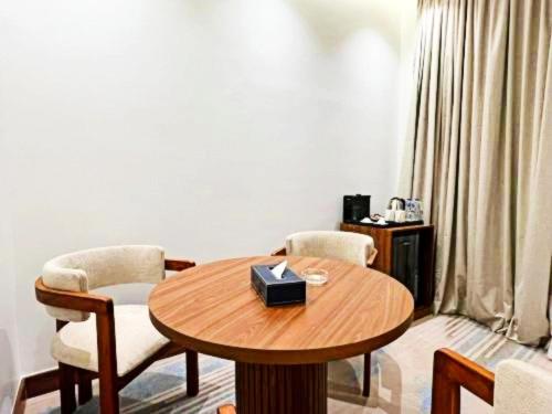 a room with a wooden table with chairs and a table sidx sidx at Sunday Luxury Central formerly Anan hotel in Riyadh
