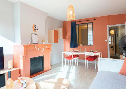 a living room with a fireplace and a table at Sur la route des étoilés - BY PRIMO C0NCIERGERIE in Tournus