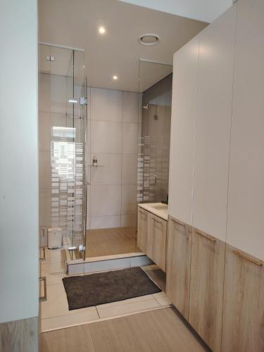 a bathroom with a shower and a sink and a mirror at Menlyn Maine Trilogy Apartment 519 in Pretoria