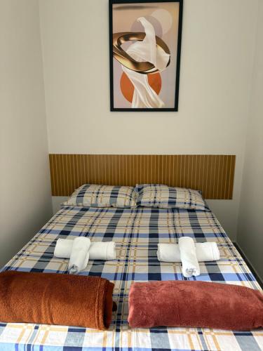 a bed with towels and a picture on the wall at FAMÍLIA CHARLEAUX in Aparecida