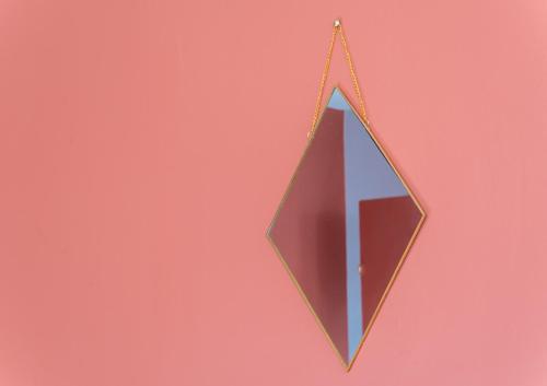 a kite hanging from a string on a pink background at Sur la route des étoilés - BY PRIMO C0NCIERGERIE in Tournus