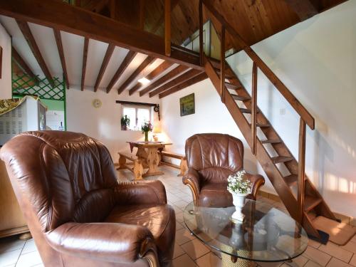 a living room with two leather chairs and a glass table at Normandy Bakery Retreat in Fourneaux