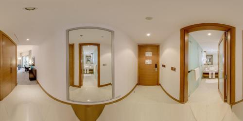 a hallway with two mirrors on the wall at Mövenpick Hotel Jumeirah Beach in Dubai