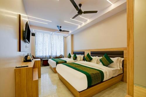 a hotel room with two beds and a television at Perfect Spot By Highly Recommended Hotels in New Delhi
