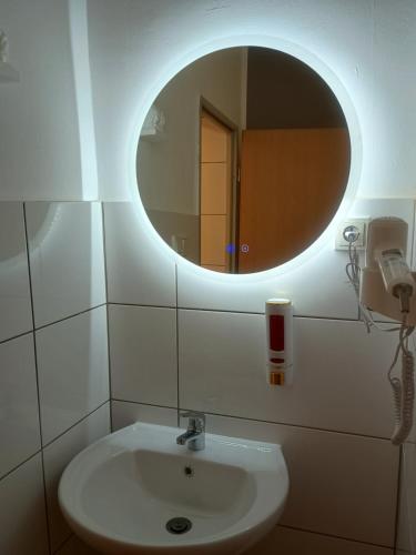 a bathroom with a sink and a mirror at Niehler Hotel in Cologne
