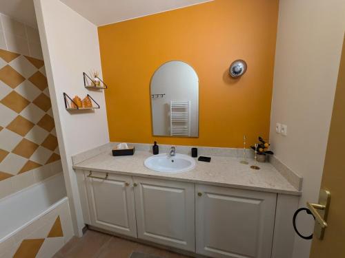 a bathroom with a sink and a mirror at Golf apartment in Saumane-de-Vaucluse