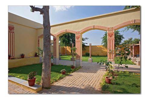 an archway in front of a house with plants at Koolwal Kothi Zinc Journey by The Fern, Nawalgarh, Rajasthan in Nawalgarh