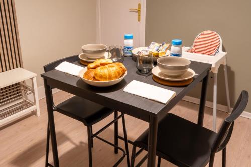 a black table with a bowl of bread on it at Sur la route des étoilés - BY PRIMO C0NCIERGERIE in Tournus