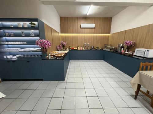 a restaurant with a counter with flowers on it at Hotel Ferrari in Rio do Sul