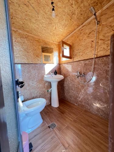 a bathroom with a toilet and a sink and a shower at Strofka in Maliq