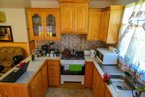 a kitchen with wooden cabinets and a stove top oven at River Breeze Villa in Soufrière