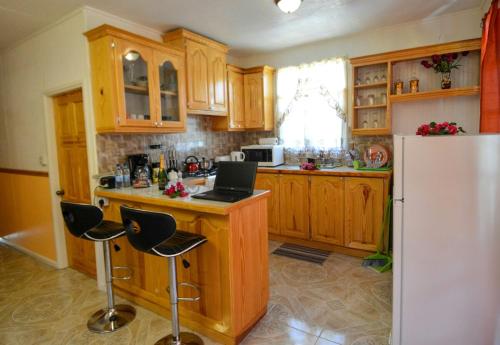a kitchen with wooden cabinets and a white refrigerator at River Breeze Villa in Soufrière