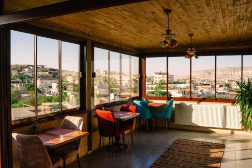 a restaurant with tables and chairs in a room with windows at Lord of Cappadocia Hotel in Goreme