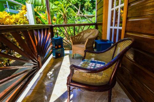 two wicker chairs sitting on a porch at River Breeze Villa in Soufrière