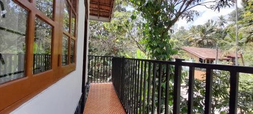 a balcony with a black railing and a tree at Le Meridien BnB in Negombo