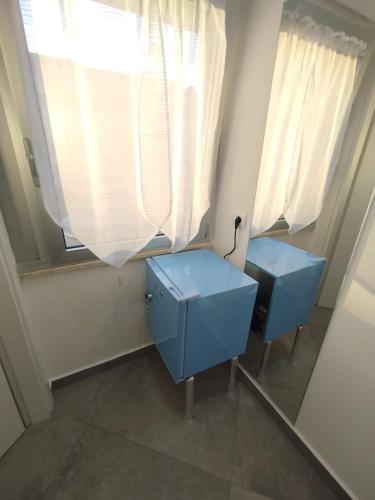 a bathroom with a blue vanity and a window at Camere d'a mare in Capo dʼOrlando