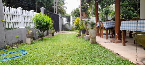 a yard with a fence with a hose on the grass at Le Meridien BnB in Negombo