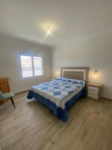 a bedroom with a bed and two tables and a window at Villa Paymu in Miami Platja